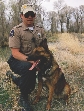 photograph of a police officer and a German Shepard dog