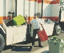 photograph of a man putting recycling into a bin