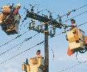 photograph of workers fixing a telephone pole