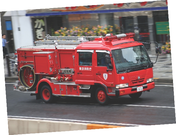 photograph of a red fire truck riding down a street