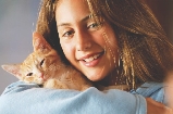 photograph of a teenage girl holding a cat