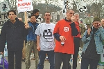 photograph of a group of people, one holding a protest sign