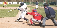 photograph of a baseball player swinging a bat, catcher and umpire at home plate