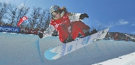 photograph of a female athlete riding on a snowboard