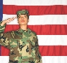 photograph of a soldier standing in front of an American flag