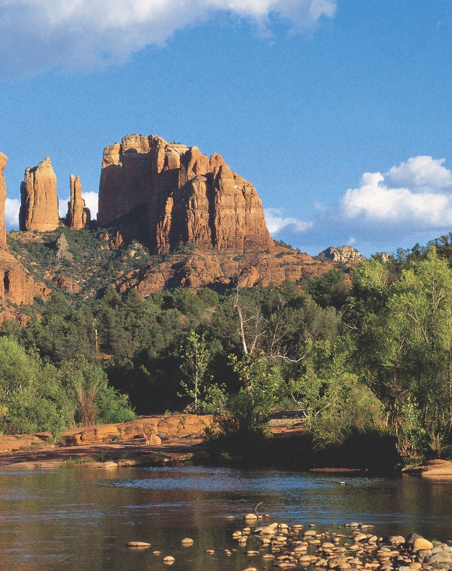 scenic photograph of Southwestern rock formations, trees, shrubs, and river