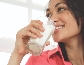 photograph of a young woman drinking a glass of milk