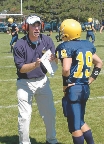 photograph of a coach and football player on a field