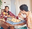 photograph of two people sitting at a table eating a meal