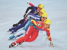 photograph of four speed skaters racing on an ice rink