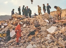 photograph of people walking through earthquake rubble