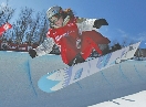 photograph of a female athlete riding a snowboard