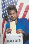 photograph of a woman putting a ballot into a ballot box