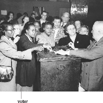 photograph of people placing voting ballots in a box