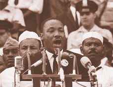 photograph of Martin giving a speech into microphones at a podium