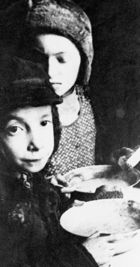 photograph of two children holding empty metal bowls