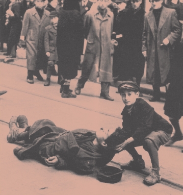 photograph of a young boy helping a man lying on a street