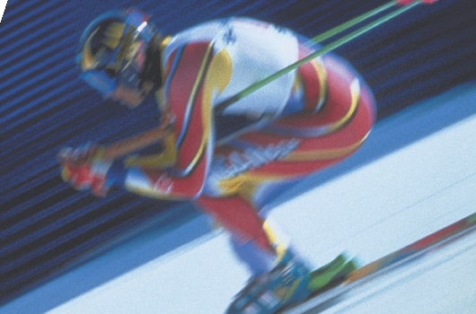 photograph of a downhill skier racing down a hill