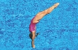 Photograph of a girl upside down with hands out about to enter water first with body straight and legs held together