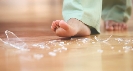 Photograph of a bare foot about to step on broken glass