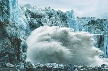 Photograph of a glacier with a huge chunk of ice falling into the sea