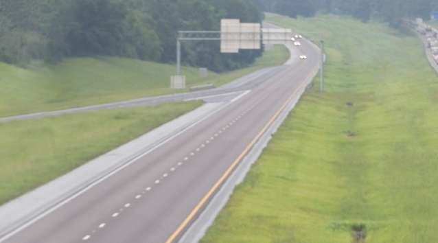 Photograph of several cars traveling along a highway