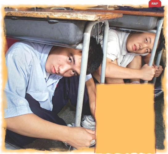 Photograph of two boys crouched down under their desks