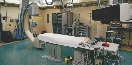 Photograph of a an imaging machine and a table for patients to lie on