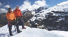 Photograph of two mountain hikers on top of a snow-covered mountain