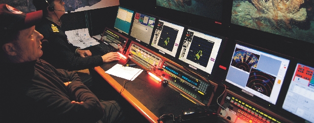 Robert Ballard and a crew member look at images of Titanic from their ship’s control room.