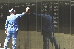 Photograph of a man touching a name on the Viet Nam Memorial