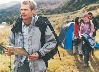 Photograph of hikers, the first one carrying a map