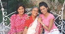 Photograph of three woman sitting on a bench and smiling