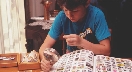 Photograph of a young boy examining stamps with a magnifier