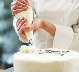 Photograph of a white cake being decorated