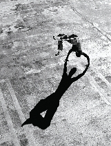 Photograph of a shadow of a boy doing a back handspring