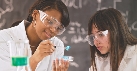 Photograph of two people with goggles working with beakers