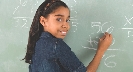 Photograph of a student doing a math problem on the chalkboard