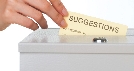 Photograph of a hand placing a card in a suggestion box