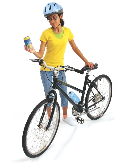 Photograph of a girl standing next to a bicycle and holding a can in one hand