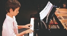 Photograph of a boy playing a piano