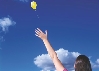 Photograph of a woman letting a balloon fly into the air