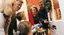 Photograph of people coming to a door carrying a gift