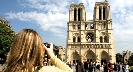 Photograph of a person taking a picture of Notre Dame Cathedral