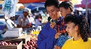 Photograph of people at an outdoor market with farm produce