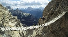 Photograph of a wooden foot bridge connecting two tall mountains