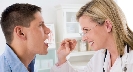 Photograph of a doctor looking into the mouth of a patient