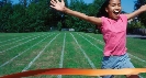 Photograph of a teenage girl running across a finish line