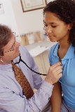 A doctor listens to a patient’s breathing.