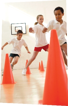 Photograph of three students running around cones in a gym